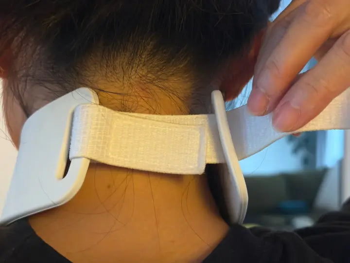 Free strap end threaded through the second slot at the back of the neck