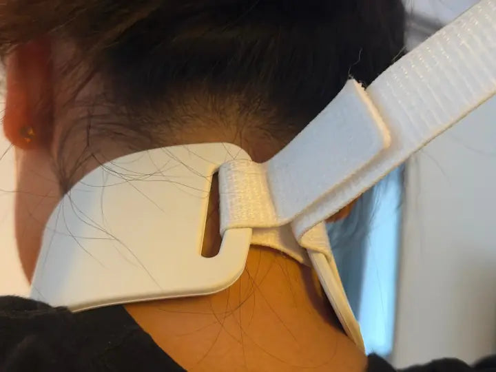 Strap fastened at the back of the neck, collar in place